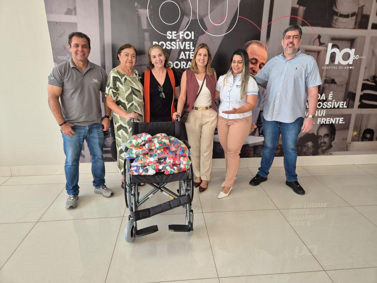 Representantes do Cartório de Colmeia-TO entregando a cadeira de rodas cheia de tampinhas no Hospital de Amor do Tocantins